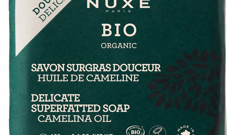 NUXE Jabón Dermatológico Suavidad, NUXE BIO 100 gr Limpia eficazmente y con suavidad. Rostro y Cuerpo. 99 % de ingredientes de origen natural 73 % de ingredientes procedentes de la agricultura ecológica Este jabón dermatológico bio* limpia eficazmente rostro y cuerpo respetando todos los tipos de piel gracias a su textura de tratamiento cremosa enriquecida con Aceite de Camelina Bio. Restos de maquillaje, impurezas y contaminación se desvanecen bajo su espuma fina y cremosa para dejar la piel limpia, perfectamente nutrida y calmada. Su reconfortante fragancia ofrece la suavidad envolvente de la Flor de Azahar. Tratamiento formulado y fabricado en Francia. *con certificación BIO.
